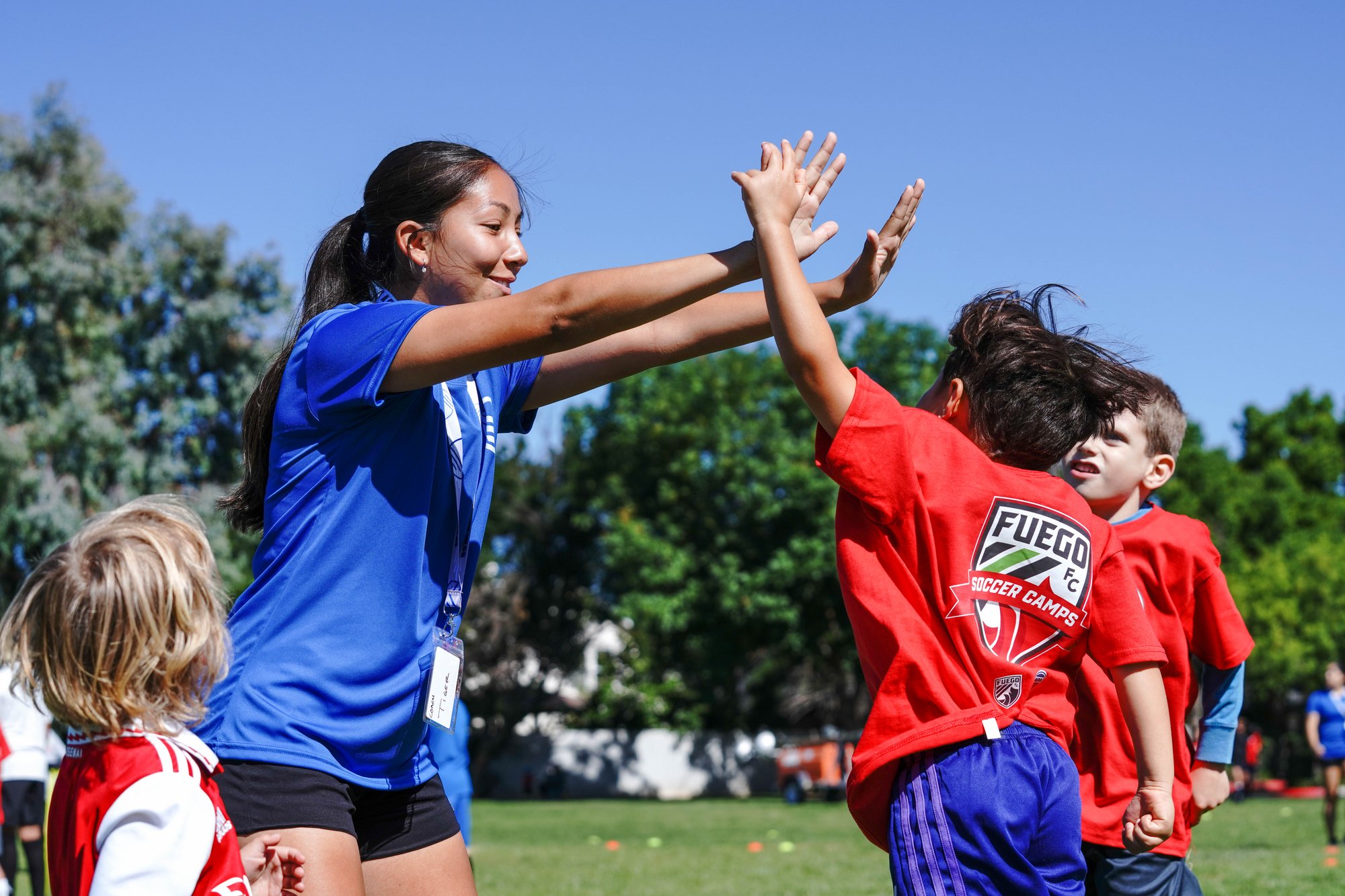 woman coach high-fiving kids during a game